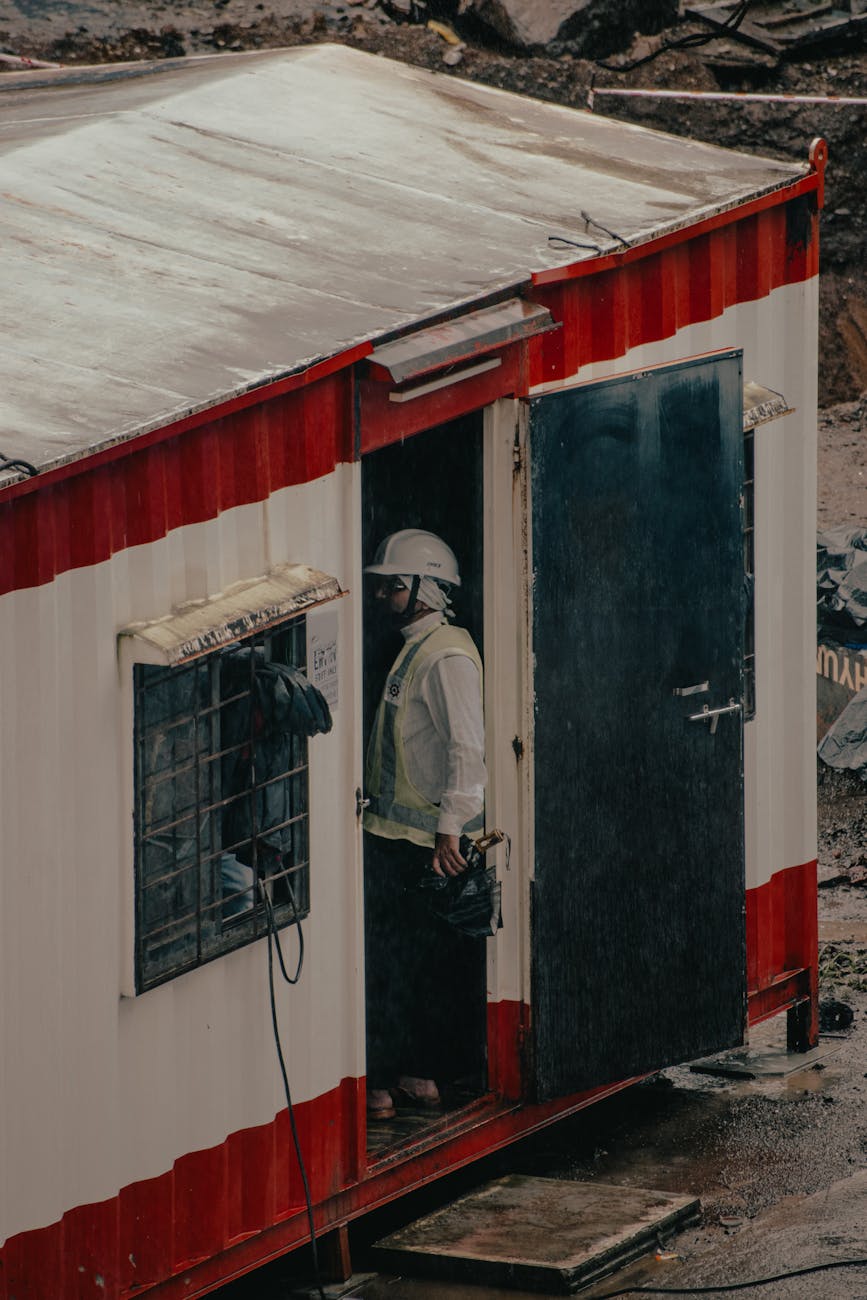 Construction project coordinator with laptop at job site trailer office