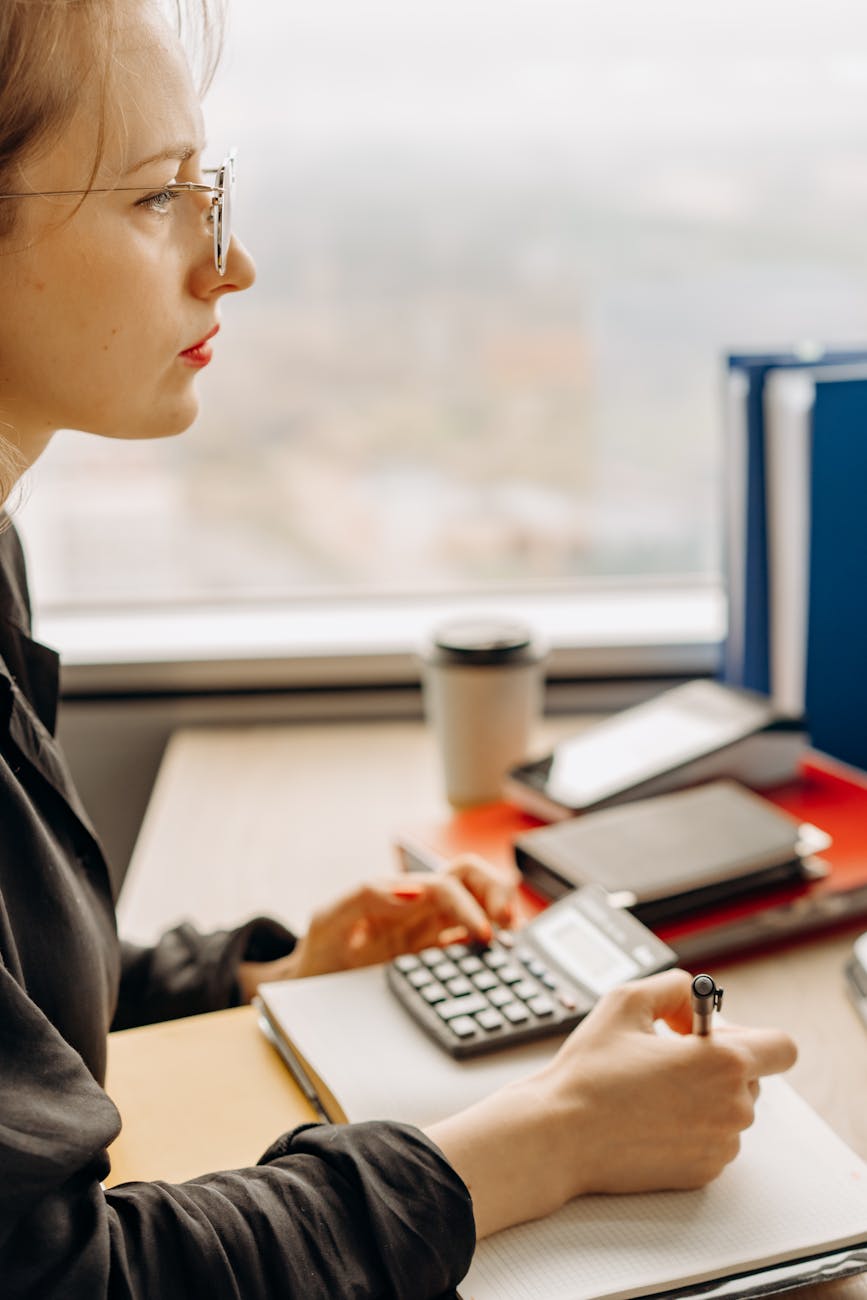 Bookkeeper working on spreadsheet at accounting office with dual monitors