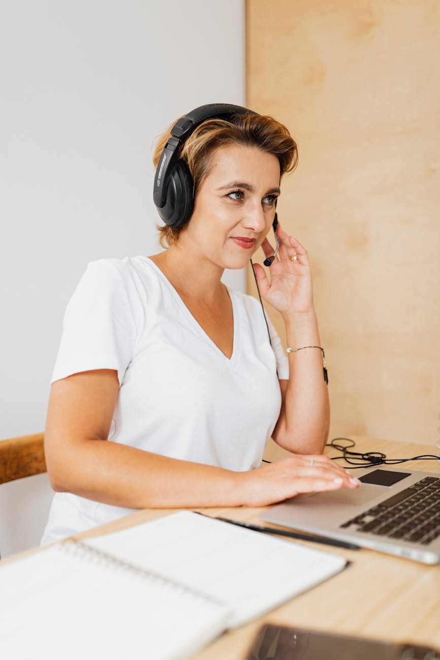 Happy remote worker at home office desk with headset smiling during video meeting