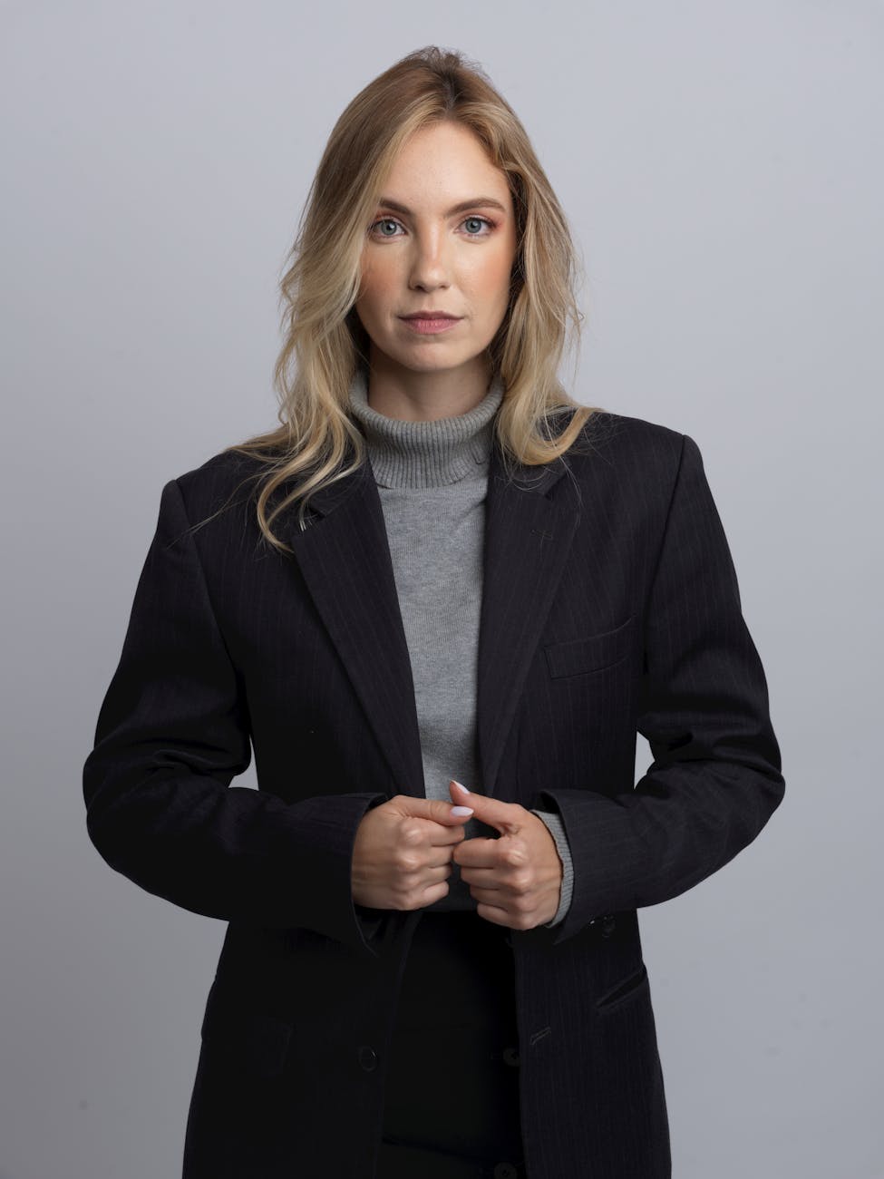 Professional woman with glasses in blazer headshot neutral background